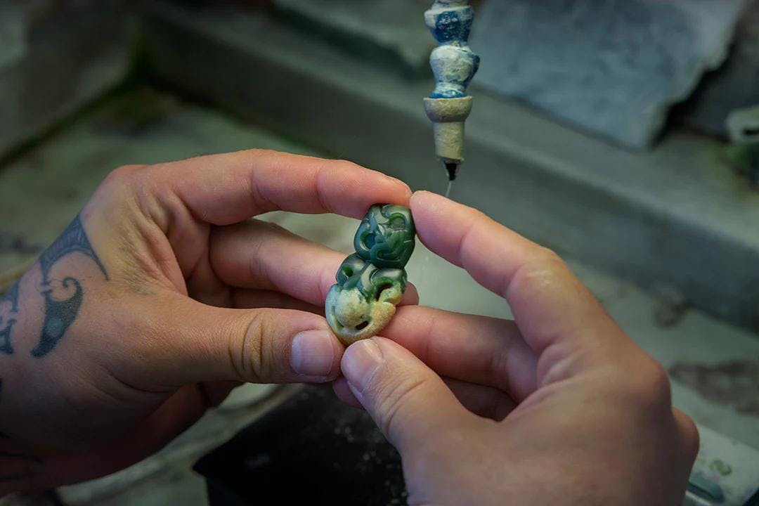 person holding a jade figure